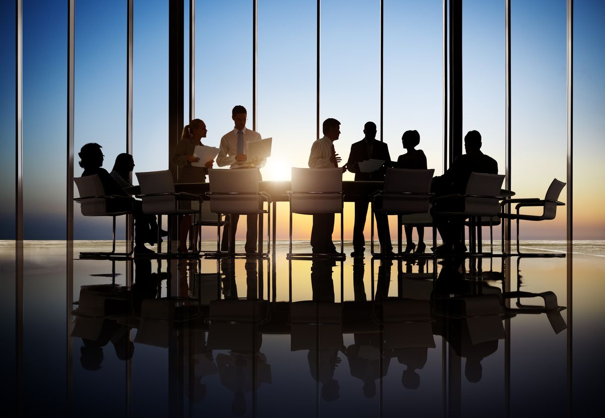 Financial professionals meeting in a boardroom at sunset